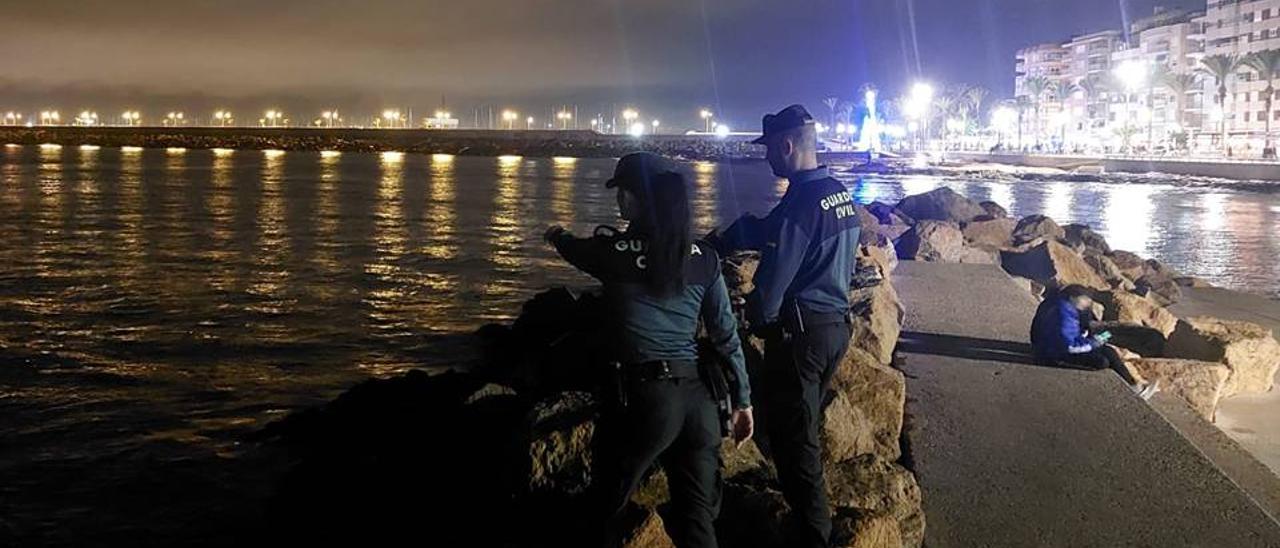 Imagen de dos agentes de la Guarcia Civil en uno de los espigones de las piscinas naturales de Torrevieja, junto al paseo de Juan Aparicio