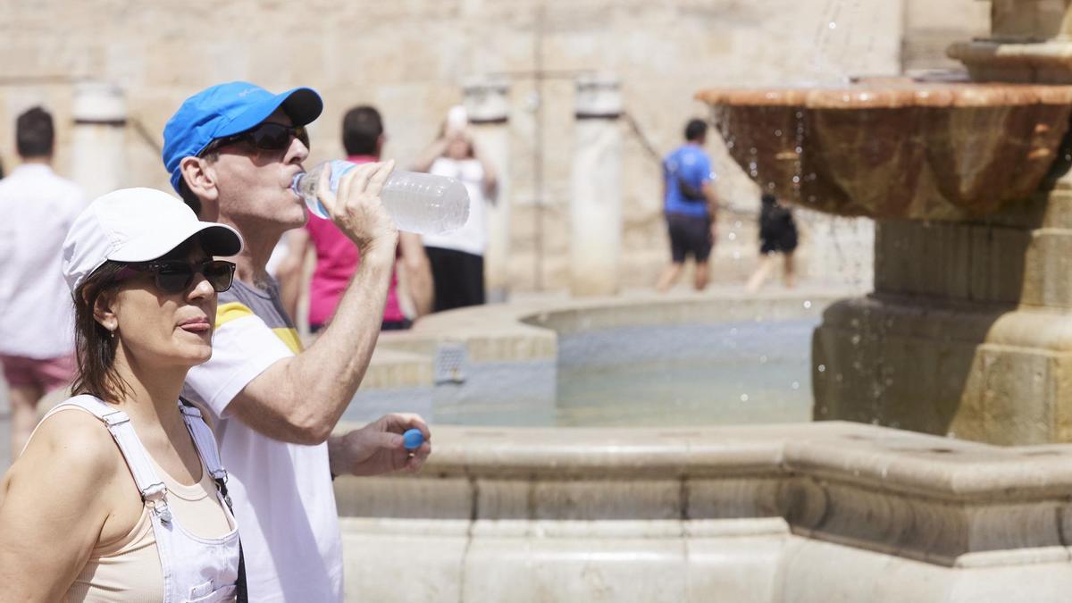 Un señor bebe agua para combatir el calor.