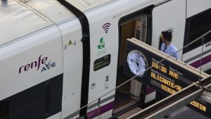 Archivo - Un trabajador de Renfe en las puertas de un AVE, en la estación Puerta de Atocha, a 3 de agosto de 2022, en Madrid (España).