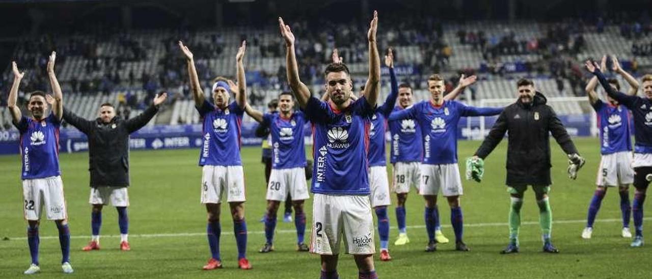 Diegui Johannesson dirige a sus compañeros del Oviedo en un saludo vikingo en el Tartiere. A la izquierda, Javi Rozada habla con él en el partido ante el Extremadura, el último que disputó.