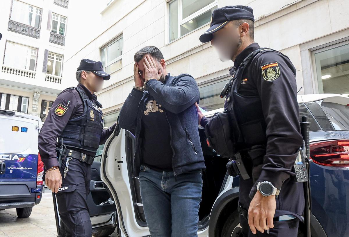 Un acusado se tapa la cara al llegar a la Audiencia de Alicante.