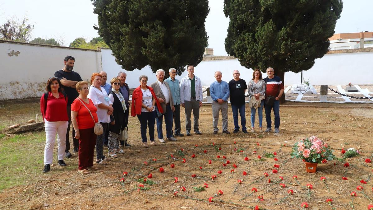 Acto de homenaje de Dejadnos Llorar en la fosa del cementerio de La Salud. Al fondo, las fosas de los militares y el muro blanqueado.