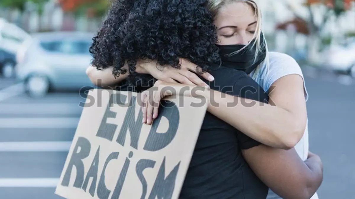 Una mujer africana abraza a una mujer caucásica durante una manifestación contra el racismo.