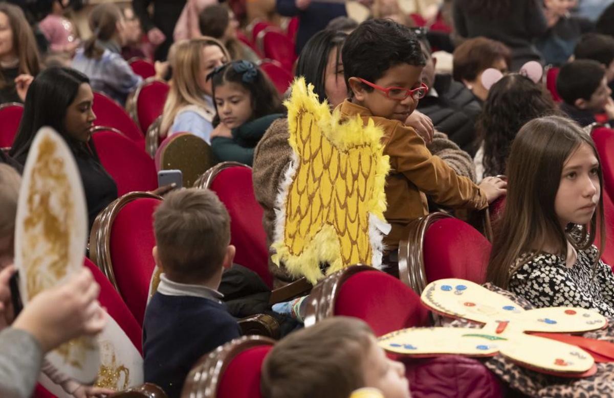 Los niños en el teatro, preparados con sus alas para asistir a la función, y, sobre estas líneas, Serena Pérez (Cenerentola), hostigada por los títeres que representaban a las malvadas hermanastras. | Miki López