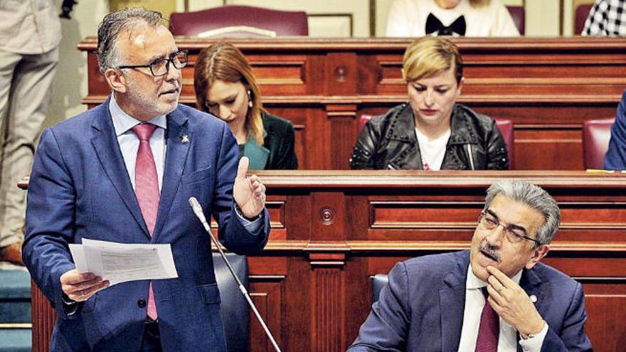 Ángel Víctor Torres, de pie interviniendo, junto a Román Rodríguez, ayer en el pleno del Parlamento de Canarias.