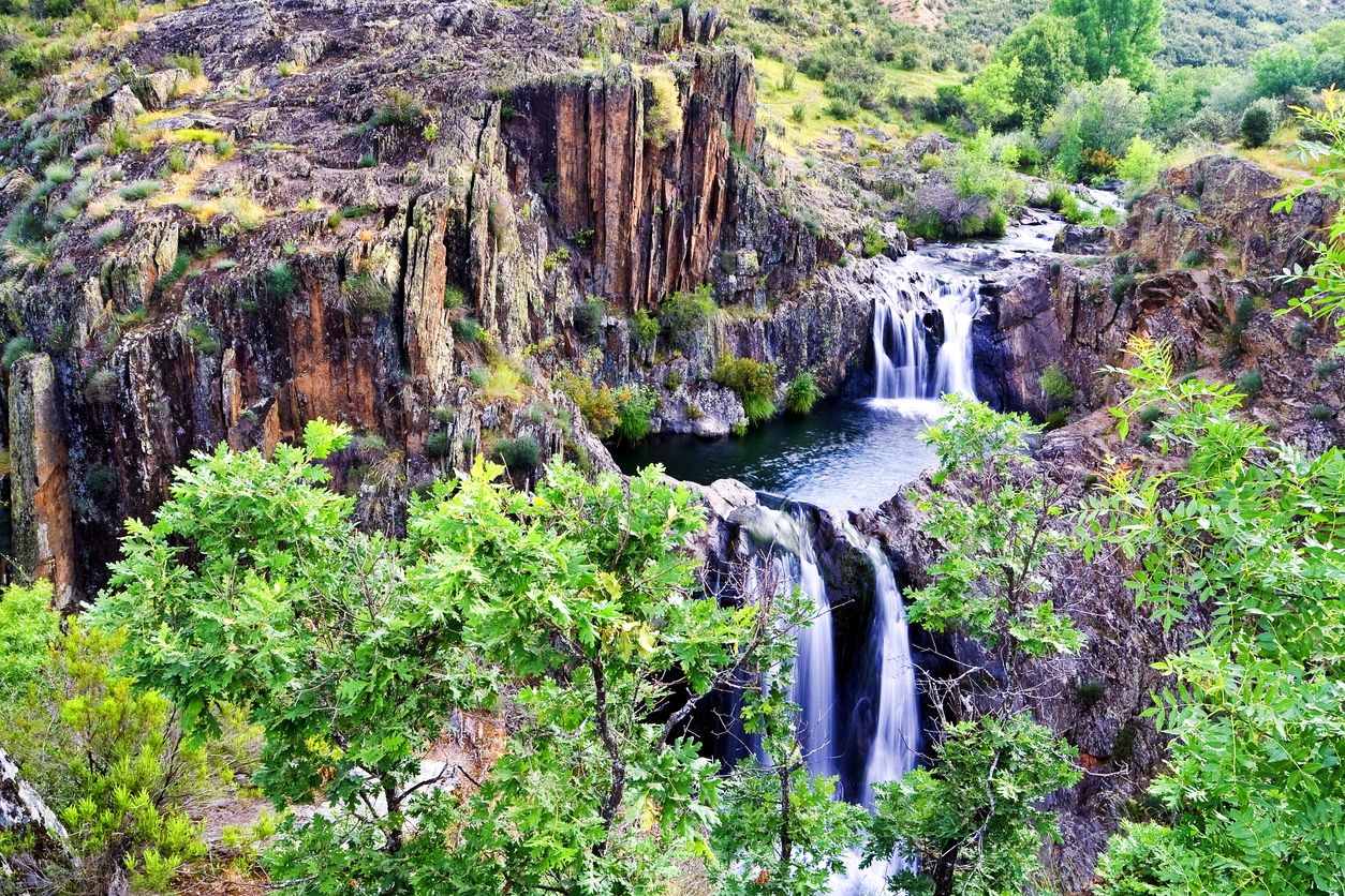 No es una cascada: son varias pozas encajadas entre roca oscura, musgo y humedad permanente.