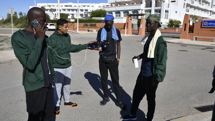 Un grupo de migrantes conversa en los exteriores de un hotel de Almería tras haber sido trasladados desde Canarias. | | EFE