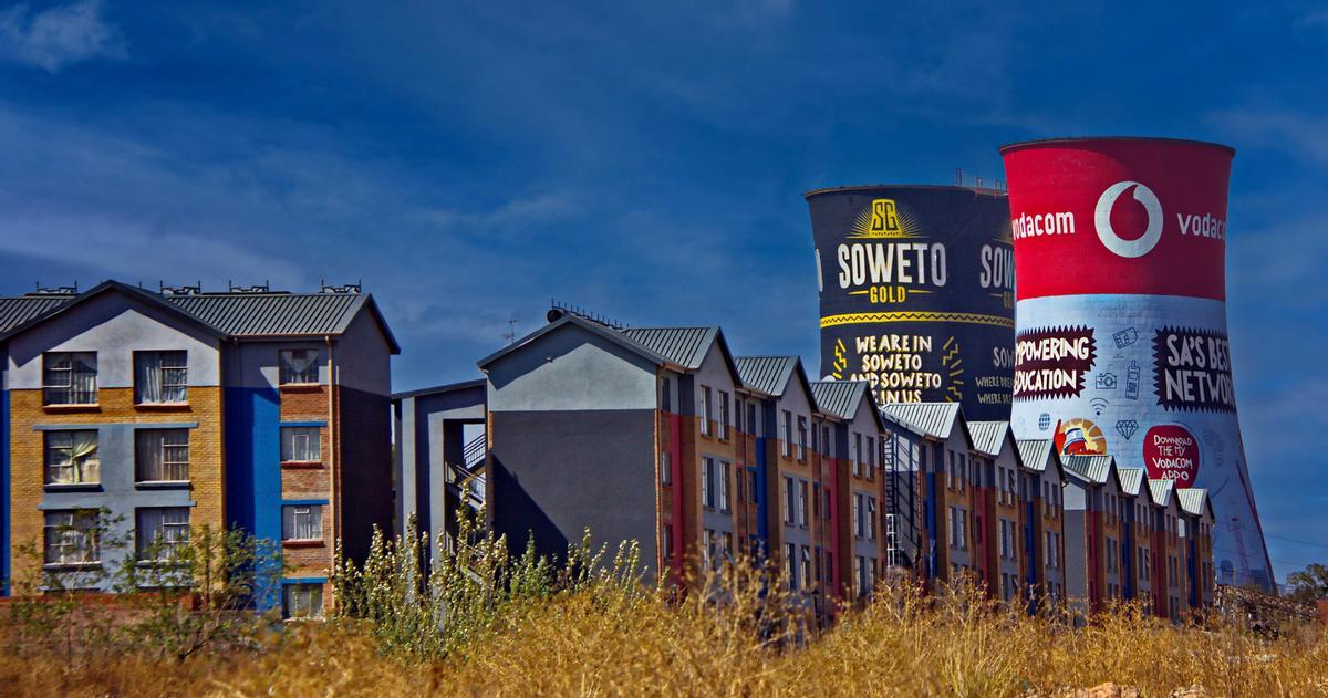 Soweto Towers (o Orlando Towers) con una decoración vívida detrás de edificios residenciales, Johannesburgo, Sudáfrica