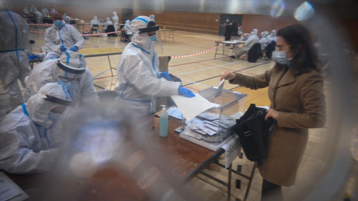 Votación con los miembros de la mesa con los epis puestos, en el Pabellon Esportiu de la Espanya Industrial.