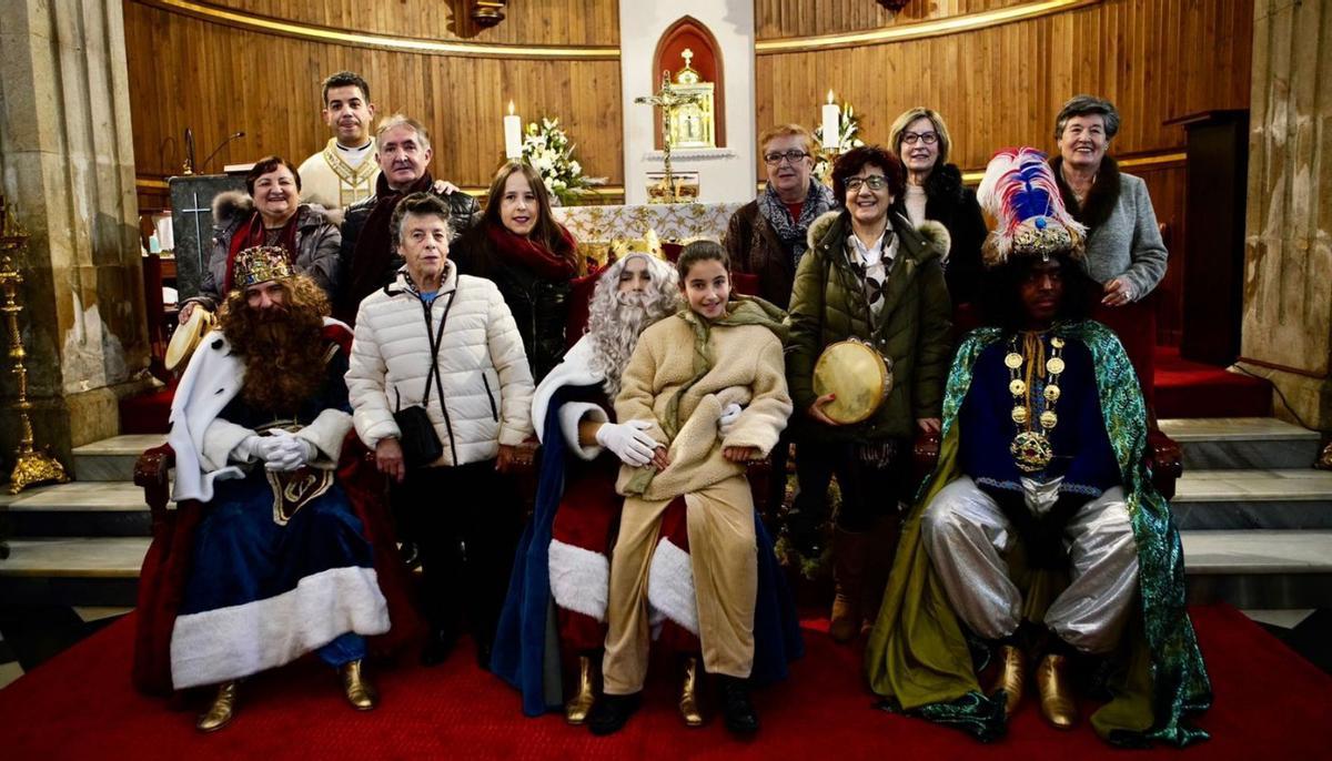 Sus Majestades posan con algunos niños, ayer, en la iglesia parroquial de Lalín.