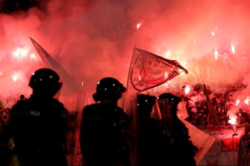 Decenas de aficionados con bengalas durante un partido de fútbol en Belgrado.