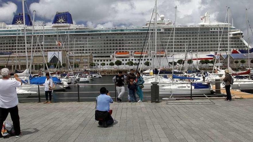 Cruceristas fotografían a sus acompañantes con el &quot;Britannia&quot; de fondo ayer en Vigo. // M. C.