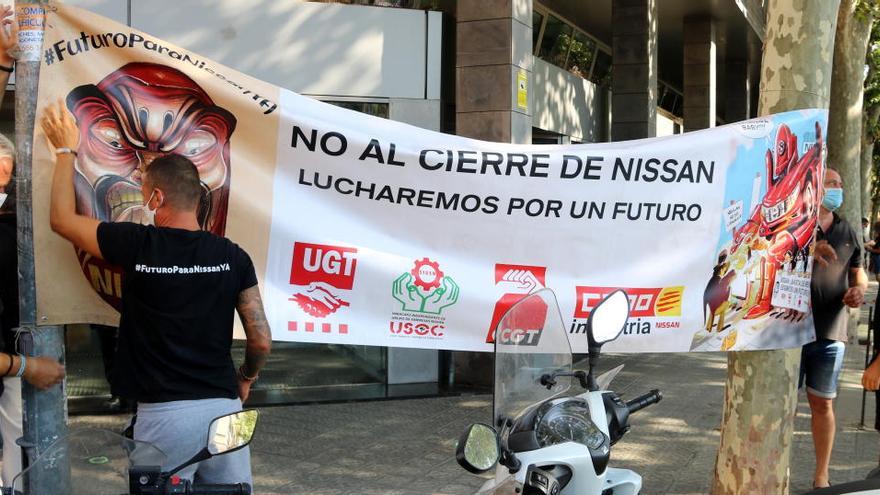 Treballadors de Nissan col·loquen una pancarta a les portes del Servei de Relacions Laborals