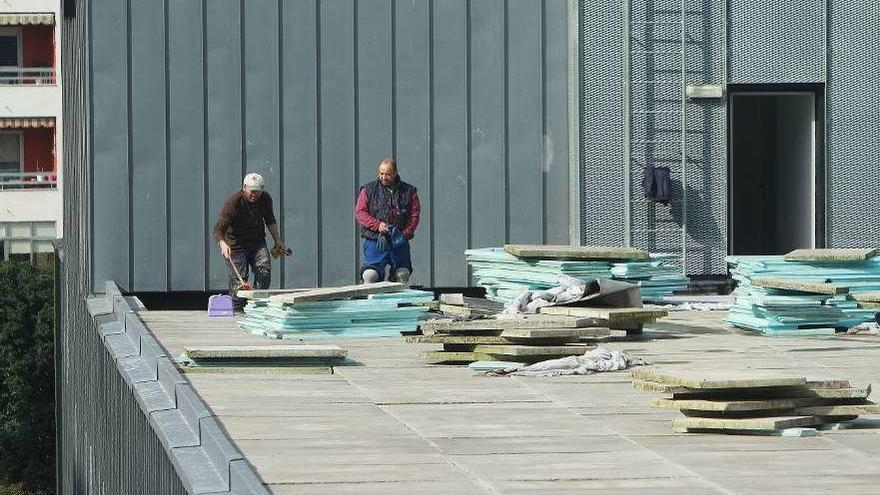 Dos operarios trabajando, ayer, en la cubierta del nuevo centro de salud de O Couto. // Iñaki Osorio