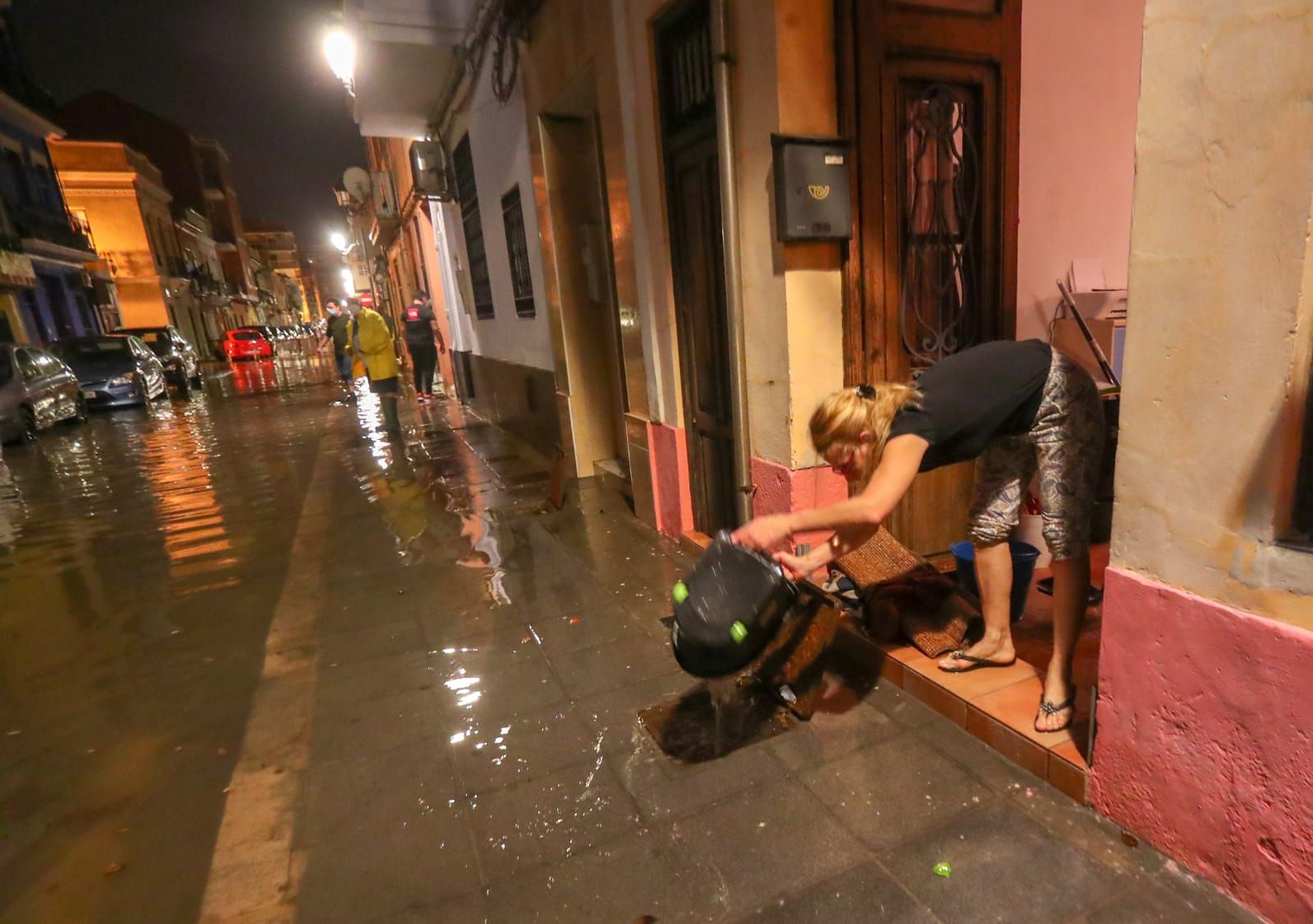 Vecinos del Cabanyal achican el agua que ha entrado en sus casas