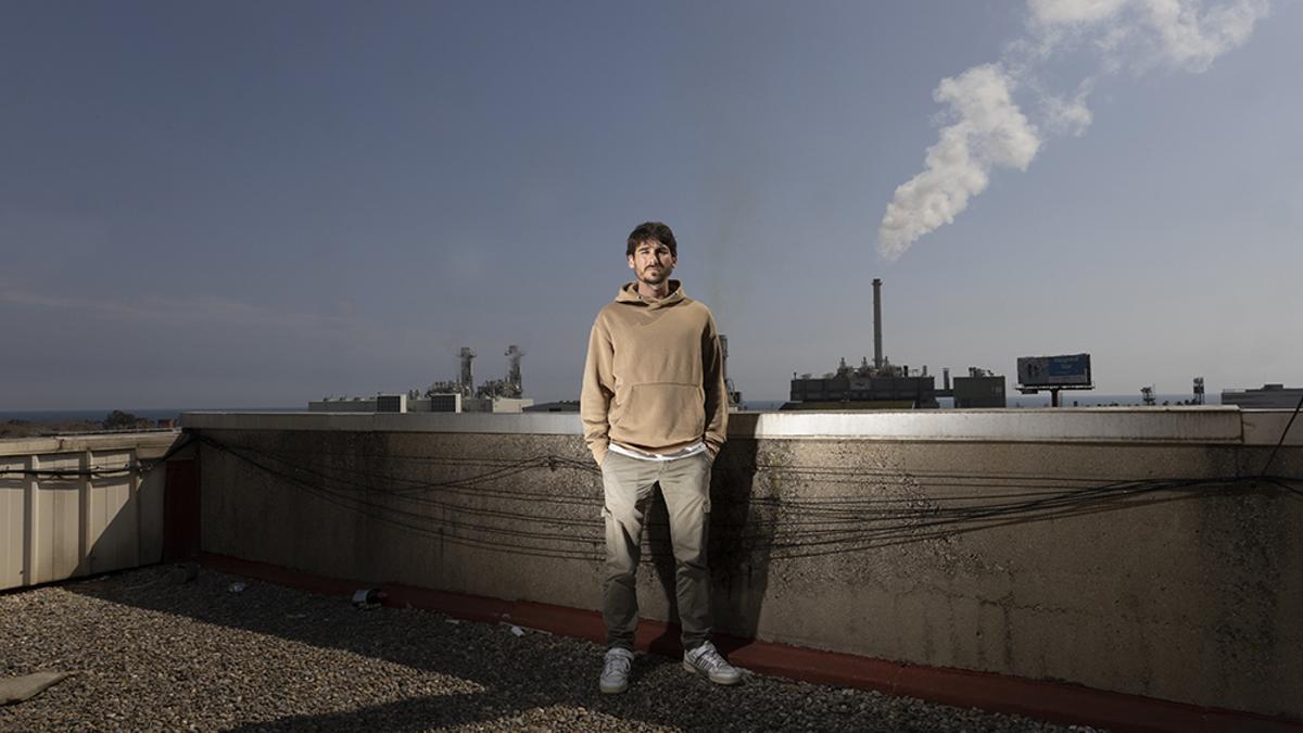 Aitor Fernández García, retratado con una columna de humo de la incineradora de Tersa al fondo, en Sant Adrià de Besòs.