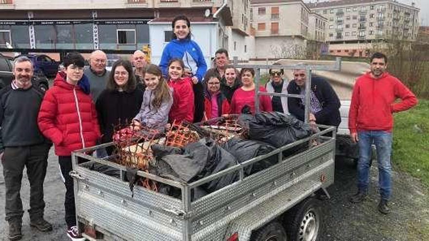 Participantes, ayer, en la limpieza del río Toxa con lo recogido.