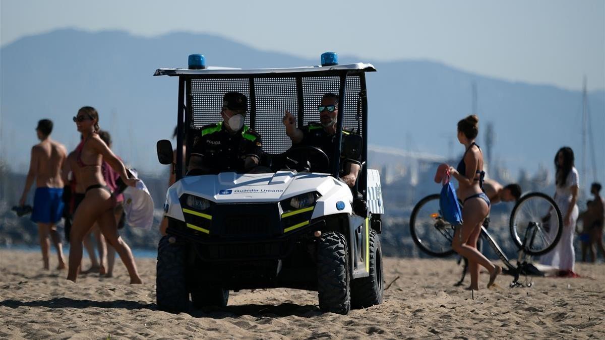 Un vehículo de la Guardia Urbana patrullando, esta mañana, por la playa de la Barceloneta.