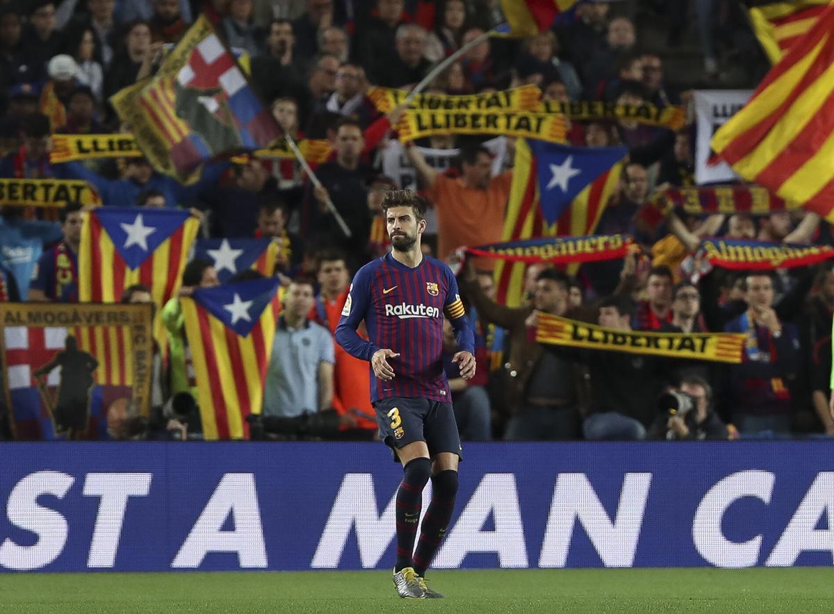 Gerard Piqué, en primer plano; al fondo, aficionados del Barça en el Camp Nou