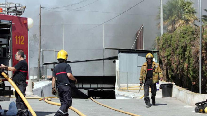 Los bomberos, en plena tarea de extinción en la nave que ocupaba un sótano.