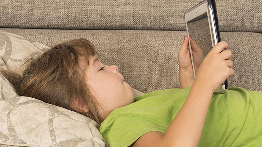 Una niña juega con una tablet.