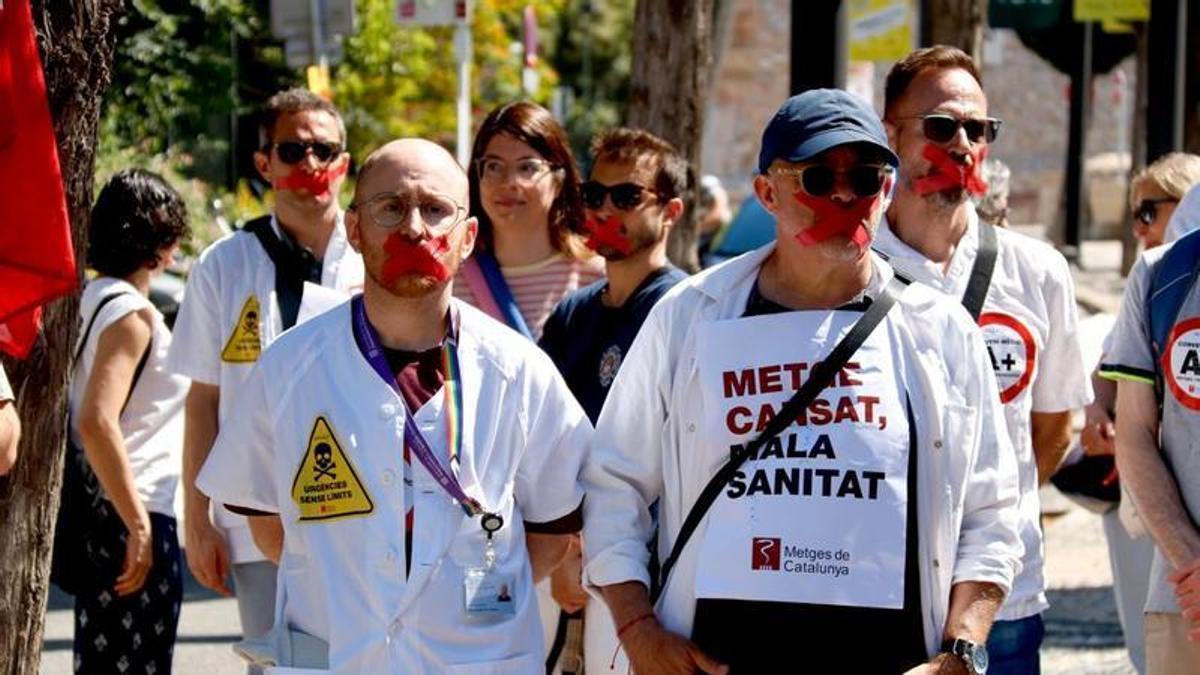 Imatge d'arxiu de dos metges amb cinta adhesiva a la boca com a mostra de protesta
