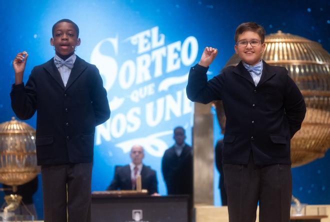 Adam Lucas Kadmiri (i) y Sergio Abaga (d), cantan un quinto premio, el número 37.876 durante la celebración del Sorteo Extraordinario de la Lotería de Navidad 2024, en el Teatro Real, a 22 de diciembre de 2024, en Madrid (España). El Estado reparte hoy un total de 2.702 millones de euros en premios, lo que supone 112 millones más que el año pasado. Para este sorteo se han puesto a la venta 193 millones de décimos de Lotería de Navidad. Este año la emisión consta de 193 series (ocho más que el anterior) de 100.000 números cada una, y asciende a 3.860 millones de euros, de los que se repartirá un 70% en premios. 22 DICIEMBRE 2024;SORTEO;NAVIDAD;LOTERIA Eduardo Parra / Europa Press 22/12/2024. Eduardo Parra;