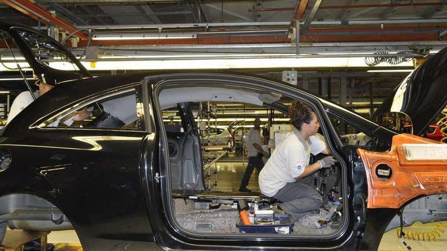 Una empleada trabaja en la fabricación de un coche en la fábrica de Figueruelas.