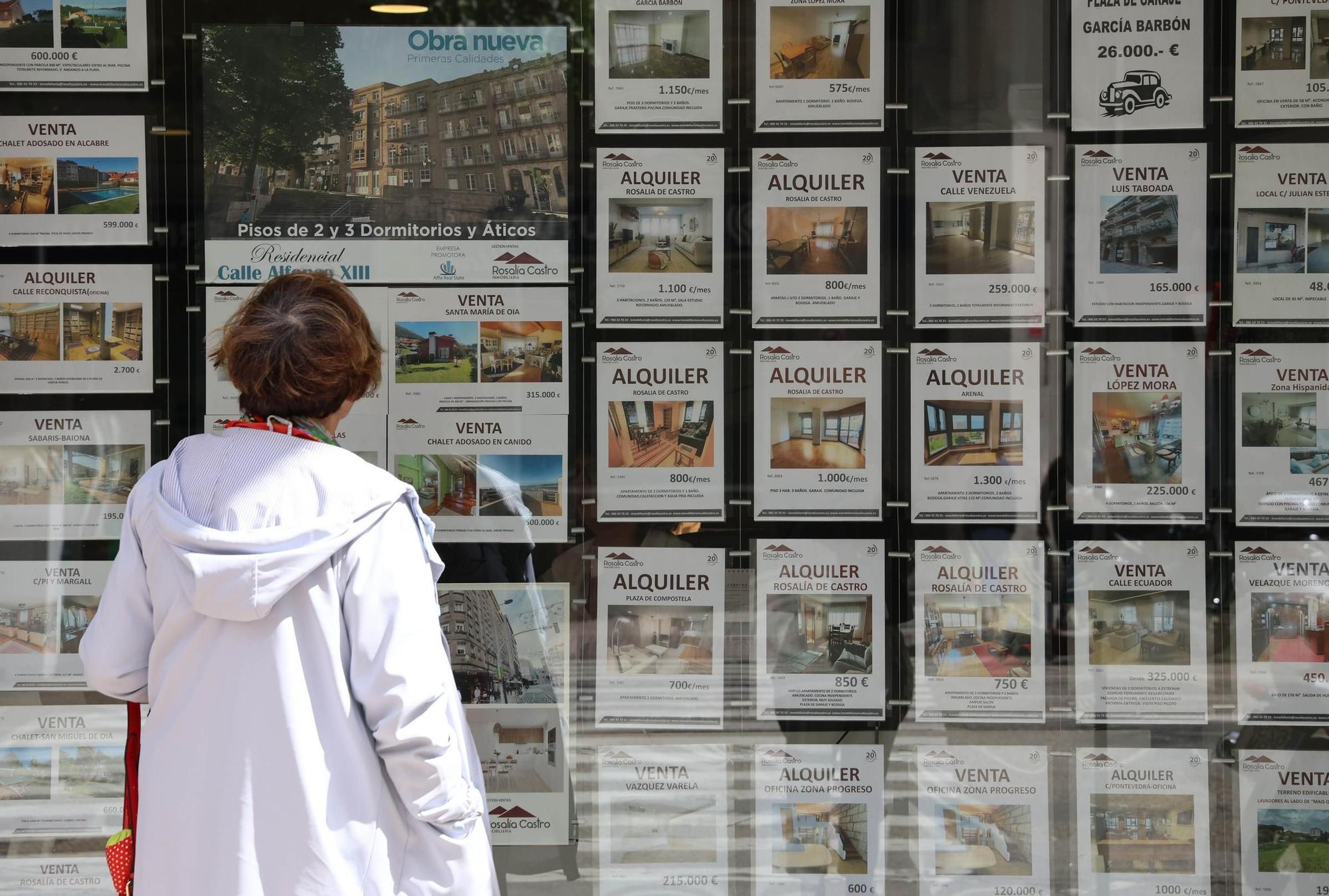 Una mujer observa el escaparate de una inmobiliaria en Vigo.