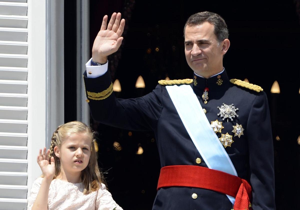 El Rey y su heredera, Leonor, saludan desde el balcón del Palacio Real, el 19 de junio de 2014.