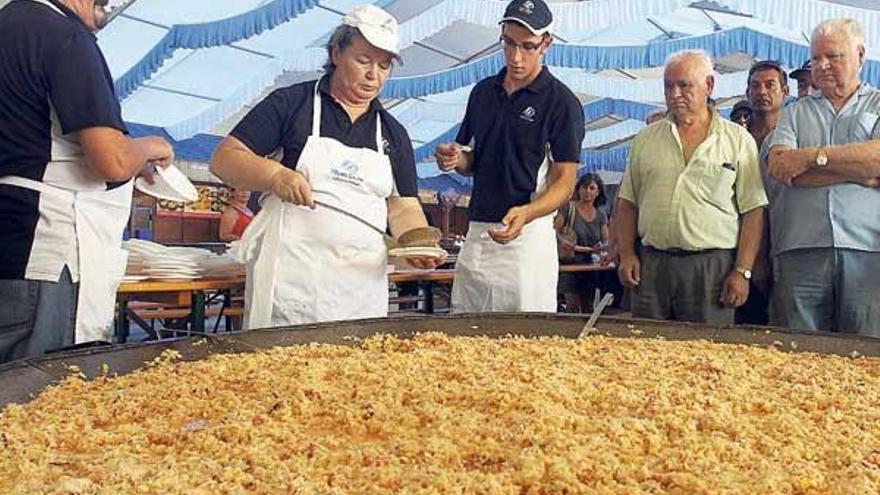 Los cocineros que prepararon el salpicón lo reparten a los curiosos y visitantes.  // Levante