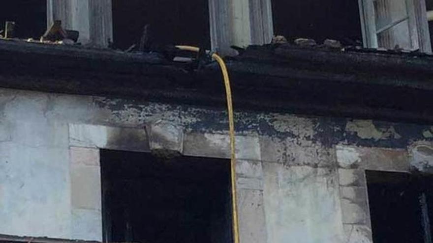 Un bombero trabaja en las labores de extinción del palacio llanisco.