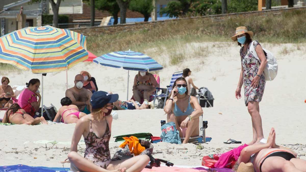 Bañistas con mascarilla en una playa de A Mariña.