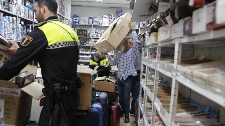 Imágenes de la inspección e incautación de efectos falsificados en uno de los bazares inspeccionados ayer en el centro tradicional de Alicante.