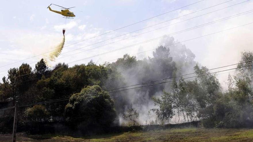 El helicóptero actuando en el incendio de Cortegada, que llegó hasta la PO-201. // Bernabé/Javier Lalín
