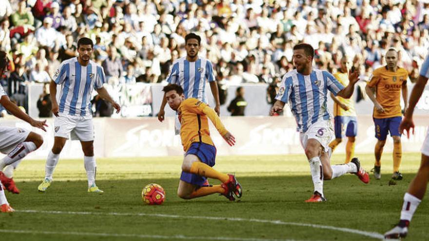 Messi se lanza por un balón cerca del área del Málaga rodeado por seis jugadores del conjunto blanquiazul.