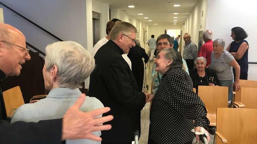 El obispo saluda a una mujer durante el encuentro.