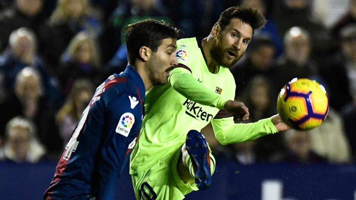 Messi prueba un centro ante Campana en el partido ante el Levante.