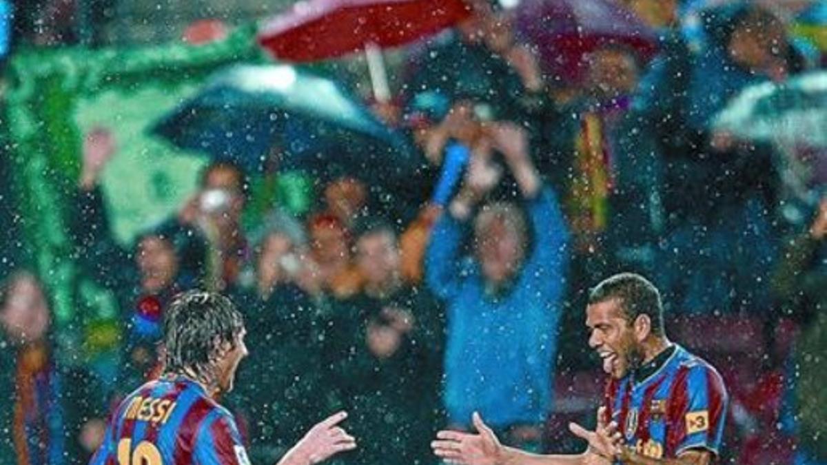 Alves felicita a Messi, bajo la lluvia, tras el cuarto gol azulgrana en el Barça-Tenerife de la pasada Liga.