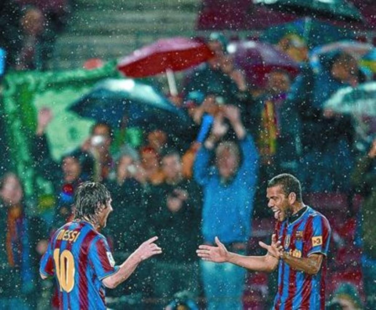 Alves felicita a Messi, bajo la lluvia, tras el cuarto gol azulgrana en el Barça-Tenerife de la pasada Liga.