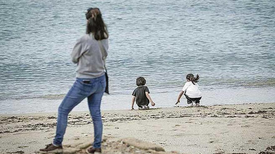 Una mujer con dos pequeÃ±os en una playa de Palma.