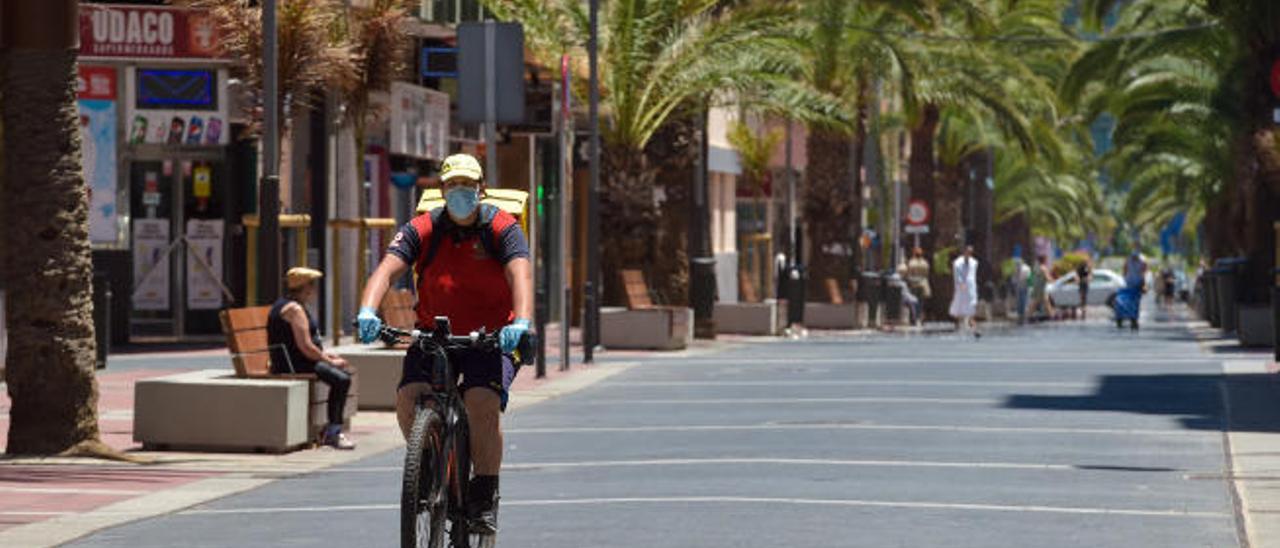 Un repartidor de comida a domicilio con mascarilla por la calle Luis Morote de la capital grancanaria.