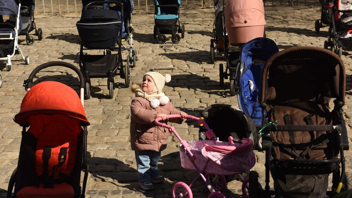 Un niño entre el más de un centenar de carritos de bebé que se han colocado hoy frente al ayuntamiento de Leópolis para llamar la atención sobre el gran número de niños que están muriendo en la guerra