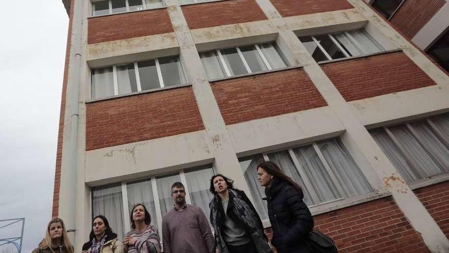 Por la izquierda, Noelia García (Consejo Escolar), María del Carmen Ruiz, Ana Taboada, Álvaro Valdés, Nuria Fernández e Isabel Méndez (AMPA), ante una de las fachadas del edificio, en la que se aprecian humedades.