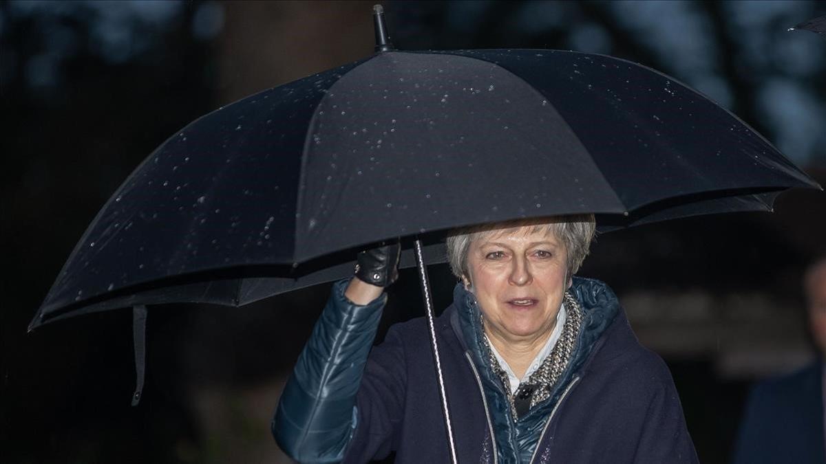 theresa may shelters from the rain 181209172125