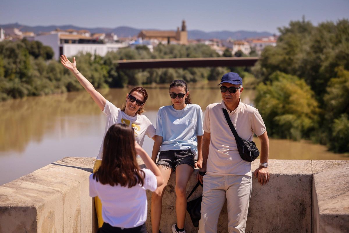 Un grupo de turistas se fotografía en el Puente Romano de Córdoba.