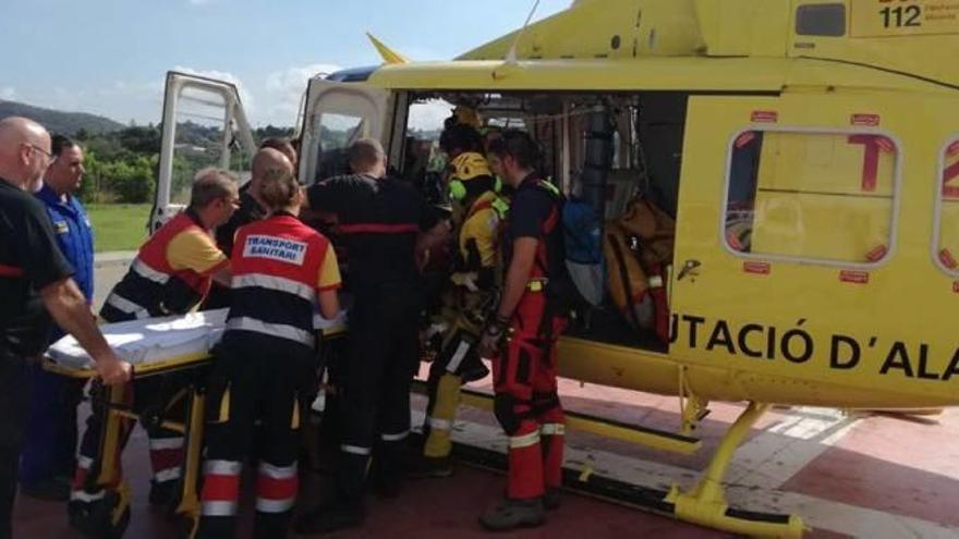 Momento en el que los bomberos del grupo de rescate bajan a la senderista del helicóptero.