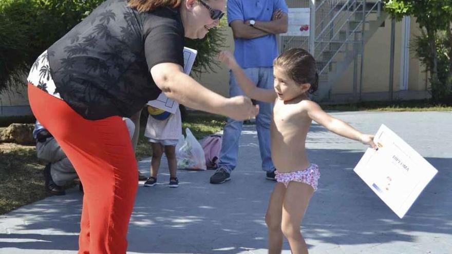 Una niña recoge su diploma de manos de la edil de Cultura.