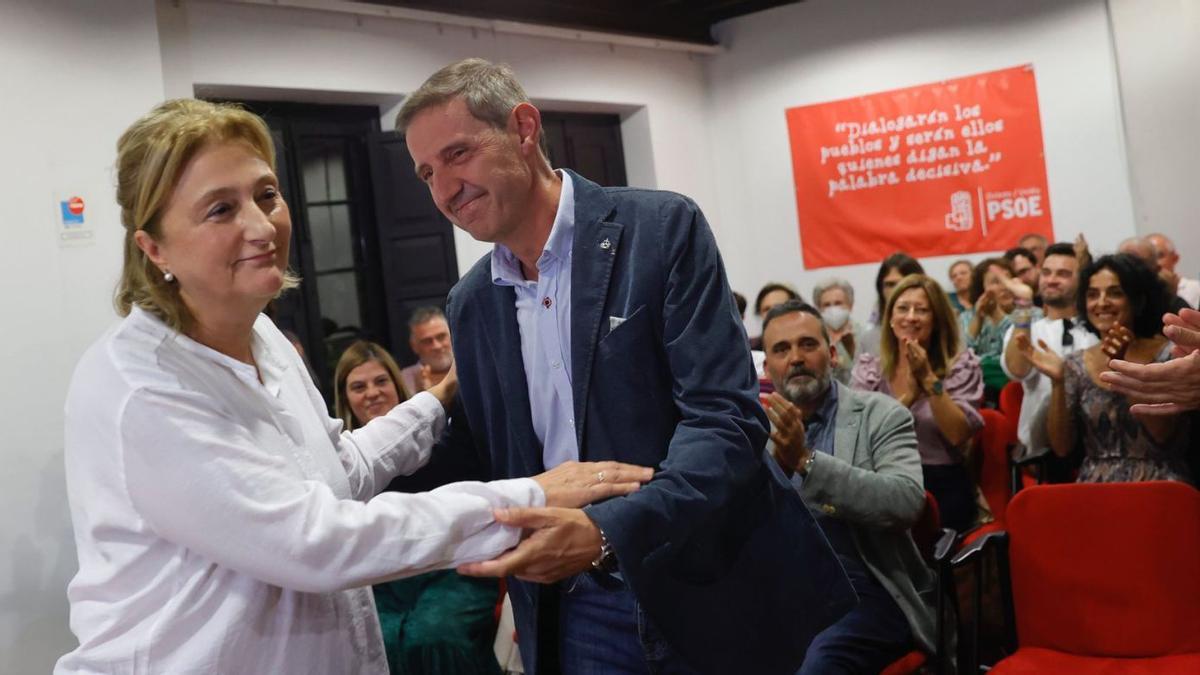 Delia Losa felicita a Carlos Llaneza por su victoria, mientras Ricardo Fernández, en segundo término entre varios militantes, aplaude al ganador. | Miki López