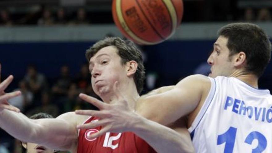 Los jugadores Kosta Perovic (D) de Serbia y Omer Asik de Turquía.